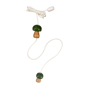 May include: A decorative light pull with two mushroom-shaped ornaments. The mushroom caps are green, and the stems are light brown. They are connected by a white cord, with a white pull at the top. A charming, playful design.