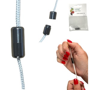 Puede incluir: Conector de cable negro para tiradores de luz. El conector está hecho de dos piezas que encajan a presión. El conector se muestra en una imagen de primer plano y en una mano que lo sostiene.