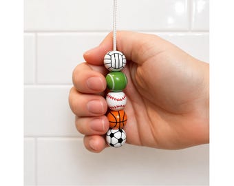 Tirador de luz con forma de pelota deportiva de madera, con cordón y conector.