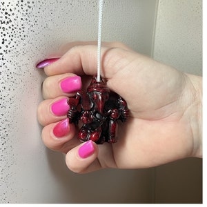 May include: A red and black resin figurine of the Hindu deity Ganesha, used as a pull chain for a light switch.
