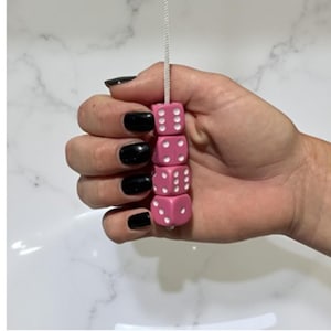 Tirador de luz rosa con forma de dado, con cable y conector.