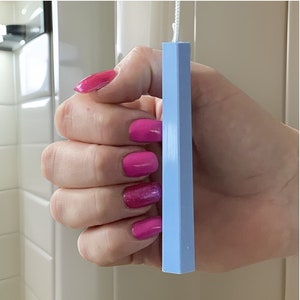 Könnte beinhalten: Eine Hand hält einen hellblauen Kunststoff-Zugschnur für einen Jalousie.