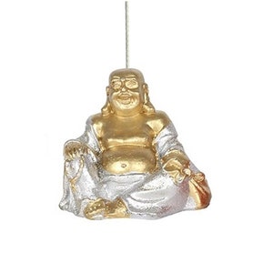 May include: A small, seated Buddha figurine with a gold head and torso, and silver robes. The Buddha is smiling and holding a small bag. A thin string is attached to the top for hanging.