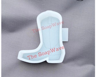 May include: White silicone mold of a cowboy boot. The mold is designed to create soap or other crafts.