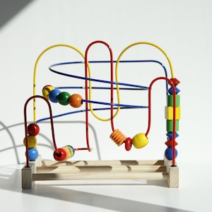 May include: A colourful wooden bead maze toy with a light wood base and brightly coloured beads. The maze features red, yellow, blue, green, and orange beads and wire tracks. The toy is designed for children's play and development.