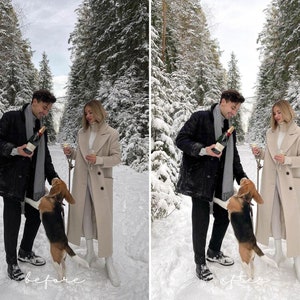Pu&ograve; includere: Una coppia in abbigliamento invernale si trova in un bosco innevato con un cane. Tengono bicchieri e bottiglie di champagne. Il cane &egrave; in piedi sulle zampe posteriori e guarda la coppia.