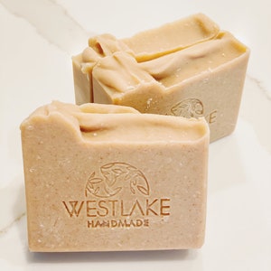 May include: Two bars of handmade soap, one with the logo "WESTLAKE HANDMADE" printed on the front. The soap is a light beige color.