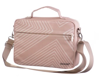 May include: A pink laptop bag with a white geometric pattern and a zippered pocket. The bag has a top handle and an adjustable shoulder strap. The brand name "DIVERSESEBE" is printed on the bottom of the bag.