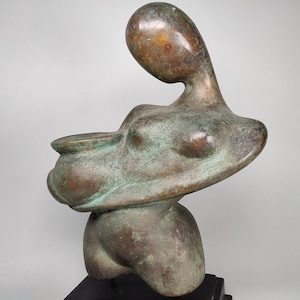 May include: Abstract bronze sculpture of a person holding a bowl. The sculpture has a green patina and is mounted on a black base.