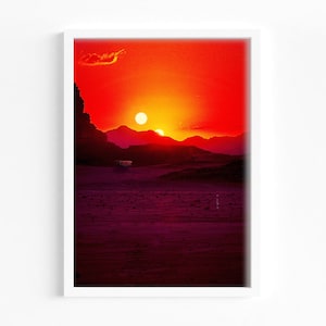 May include: A vibrant sunset over a desert landscape with two suns in the sky, one larger and one smaller. The sky is a gradient of orange, red, and yellow, with a few clouds in the distance. The mountains in the foreground are silhouetted against the sunset.