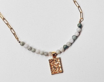 May include: A gold chain necklace with a jade green and white bead strand and a gold dragon pendant.