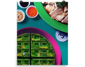 May include: A colorful art print featuring a top-down view of a meal. The composition includes a green plate with sliced meat, small bowls of sauces, and a waffle-like structure with green buildings. A white coaster with the number 3 is also visible.