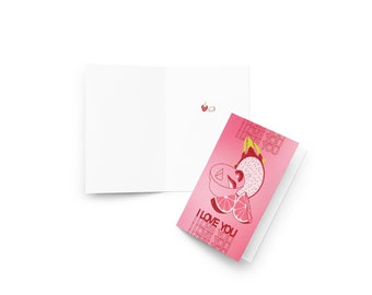 May include: Pink greeting card with a pink and white gradient background. The card features a stylized illustration of a dragon fruit, a strawberry, and a grapefruit with the text "I LOVE YOU" repeated multiple times.