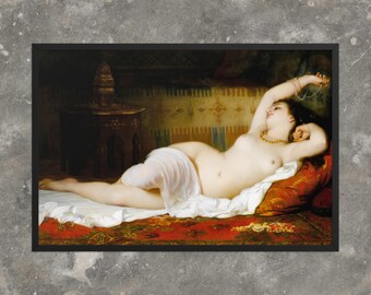 May include: A framed print of a classical painting depicting a nude figure reclining on a red and gold patterned rug. The figure wears a gold necklace and holds a strand of pearls. The background features ornate details and a dark, shadowed area.