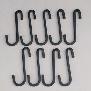 May include: Ten black metal S-shaped hooks. The hooks are all the same size and shape.