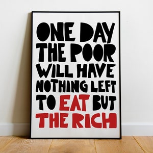 May include: A framed print featuring the text "ONE DAY THE POOR WILL HAVE NOTHING LEFT TO EAT BUT THE RICH". The text is in a bold, stylized font, with the words "TO EAT BUT THE RICH" in red.