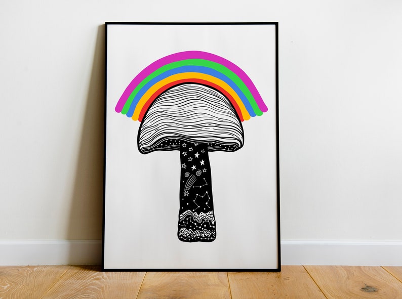 May include: Black and white art print of a mushroom with a rainbow arching over it. The mushroom's cap has a lined pattern, and the stem features stars, constellations, and a wavy design. The print is framed in a black frame.