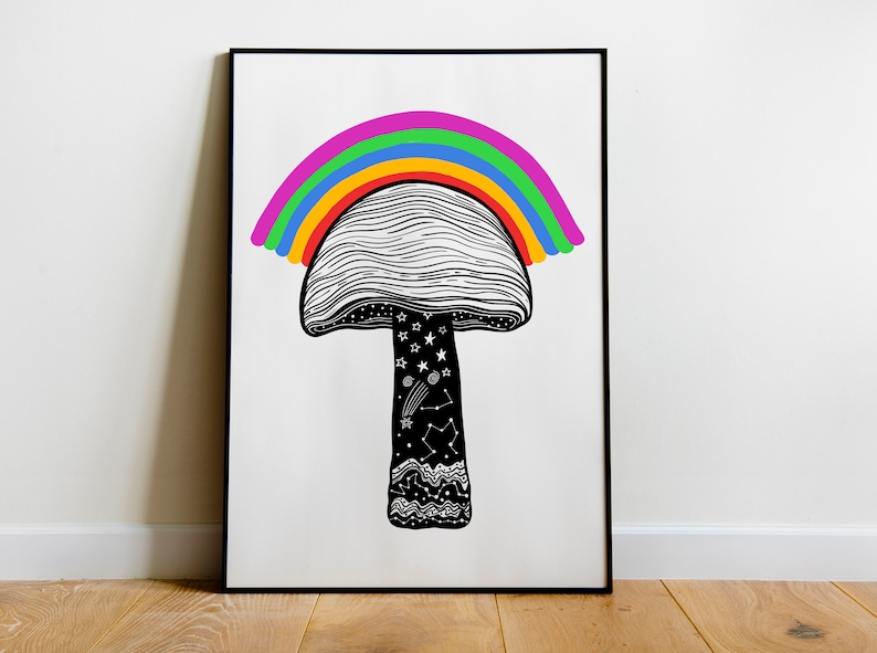 May include: A framed art print featuring a whimsical mushroom design. The black and white mushroom has a rainbow arching over it. The stem is decorated with stars, constellations, and a wavy pattern.