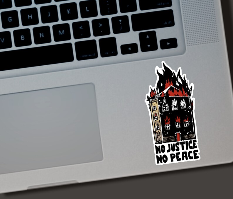Puede incluir: Una pegatina con un edificio en llamas en rojo y negro. La pegatina tiene el texto "NO JUSTICE NO PEACE" en blanco. La pegatina est&aacute; colocada en un port&aacute;til plateado.