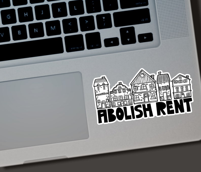 Puede incluir: Una pegatina en blanco y negro con una fila de casas estilizadas. La pegatina tiene las palabras "ABOLISH RENT" en letras negras en negrita. La pegatina est&aacute; colocada en un port&aacute;til plateado.