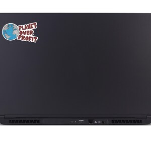 May include: Black laptop with a sticker that reads "PLANET OVER PROFIT." The sticker features a blue and white globe graphic. The laptop has a sleek, matte finish and visible ports along the bottom edge.