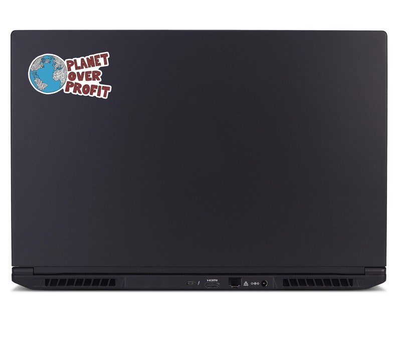 May include: Black laptop with a sticker that reads "PLANET OVER PROFIT." The sticker features a blue and white globe graphic. The laptop has a sleek, matte finish and visible ports along the bottom edge.