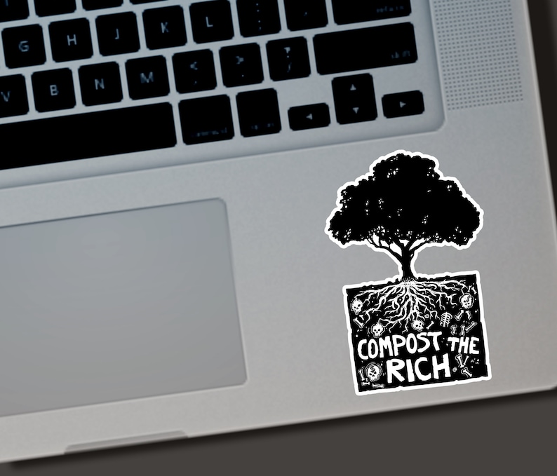 Puede incluir: Una pegatina en blanco y negro con un &aacute;rbol con ra&iacute;ces y el texto "COMPOST THE RICH". La pegatina est&aacute; colocada en un port&aacute;til plateado.