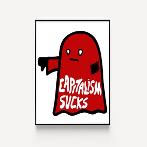 May include: A framed art print featuring a red ghost-like figure with a thumbs-down gesture. The figure has a black patch and the words "CAPITALISM SUCKS" in white. The artwork is set against a white background.