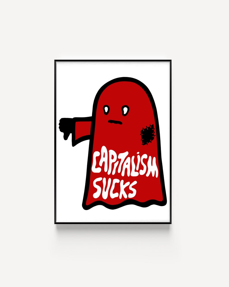 May include: A framed art print featuring a red ghost-like figure with a thumbs-down gesture. The figure has a black patch and the words "CAPITALISM SUCKS" in white. The artwork is set against a white background.