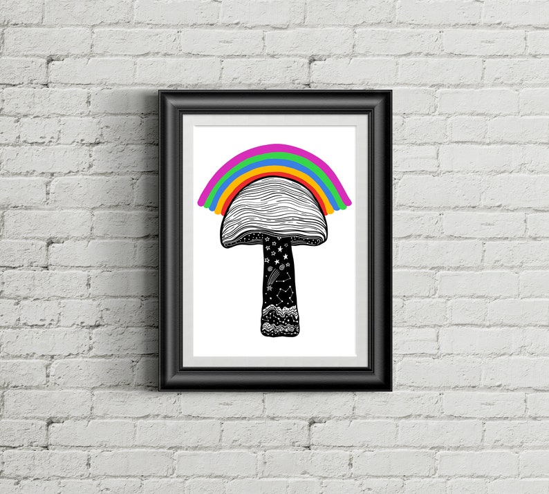 May include: Black framed art print featuring a whimsical mushroom design with a rainbow arching over the cap. The mushroom stem is black with white stars and constellations. The artwork is displayed against a white brick wall.