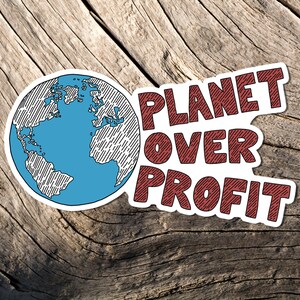 May include: A sticker with the words "PLANET OVER PROFIT" in maroon, with a blue and white globe illustration. The sticker is set against a weathered wood background, emphasizing an environmental theme.