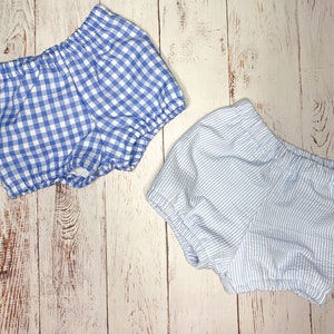 May include: Two pairs of baby bloomers. One pair is blue and white gingham, the other is blue and white striped.