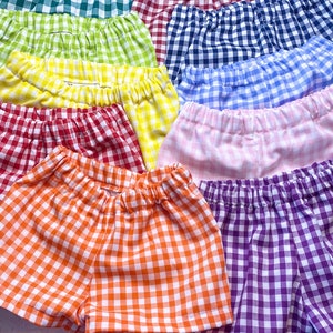 May include: A rainbow assortment of gingham shorts. The shorts are made of a soft, lightweight fabric and feature a comfortable elastic waistband. The colors include green, yellow, red, pink, blue, orange, and purple.
