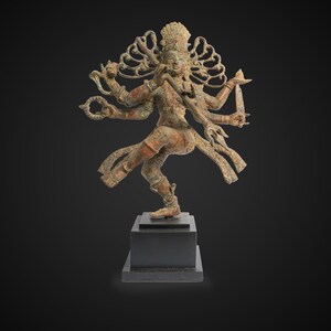 May include: A bronze sculpture of a multi-armed deity in a dancing pose. The deity has a crown and is adorned with intricate details. The sculpture is on a black wooden base.