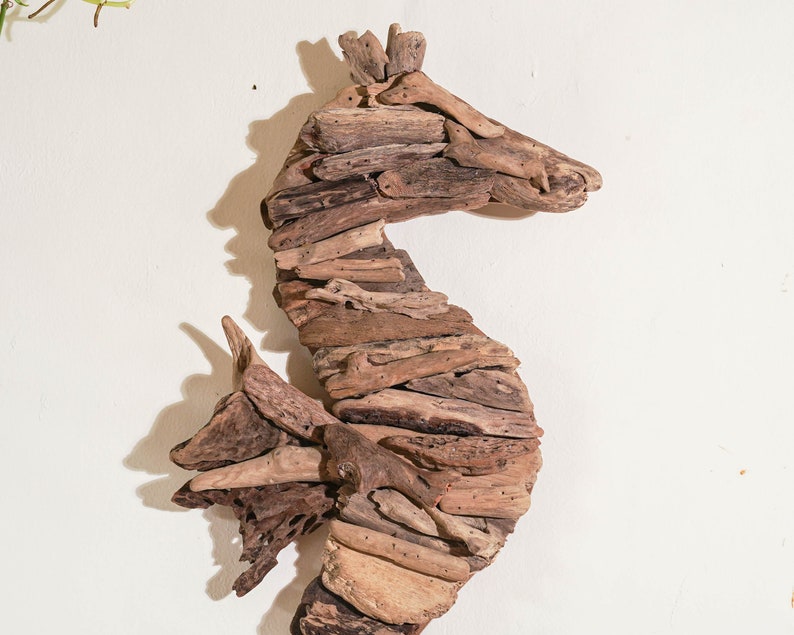 May include: A brown driftwood seahorse sculpture. The seahorse is made of many pieces of driftwood that have been carefully arranged to create a realistic shape.