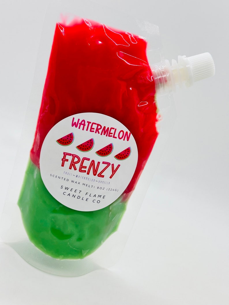 Op de afbeelding: Een rode en groene zak met een wit label waarop "Watermelon Frenzy" en "Scented Wax Melt: 8oz (226g)" en "Sweet Flame Candle Co." staat.