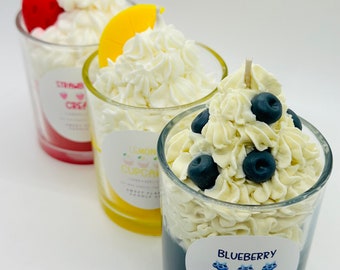 Könnte beinhalten: Drei Glasgefäße mit Schlagsahne und Fruchtbelag. Die Gläser sind mit "Strawberry Cream", "Lemon Cupcake" und "Blueberry Cream" beschriftet.