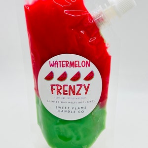 Op de afbeelding: Een doorzichtige plastic zak gevuld met rode en groene geurwax. De zak heeft een tuit voor gemakkelijk gieten. Het etiket luidt "Watermelon Frenzy" met drie watermeloenplakjes en de tekst "Scented Wax Melt 8 oz (226g) Sweet Flame Candle Co."
