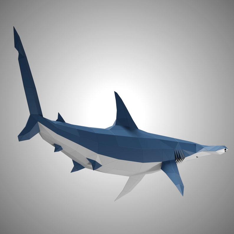 May include: A low-poly geometric sculpture of a hammerhead shark. The shark features a dark blue upper body and a white underbelly, constructed from flat triangular facets that create a sharp, angular, and modern digital aesthetic.