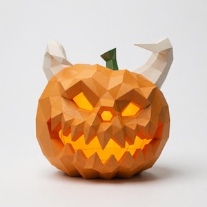Pode incluir: Uma escultura de abóbora em papel low-poly com uma superfície geométrica laranja, um caule verde e dois chifres brancos. A abóbora apresenta um rosto recortado com bordas serrilhadas e uma luz amarela brilhante que emana do seu interior.