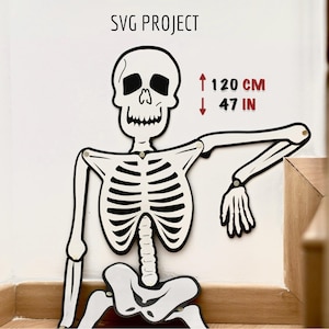 May include: A black and white skeleton cutout with a smiling face. The skeleton is 47 inches tall, or 120 cm. The skeleton is mounted on a white wall.