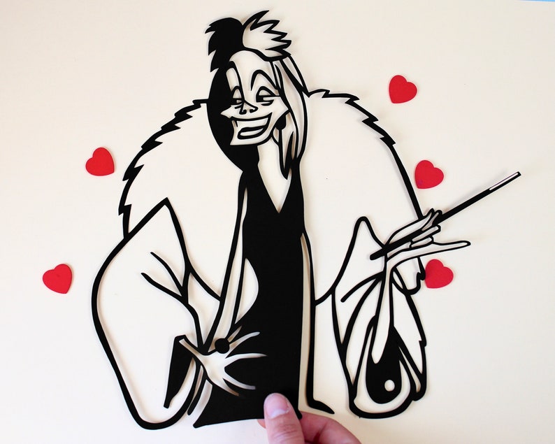 May include: A black and white paper cut-out of Cruella De Vil from the Disney film 101 Dalmatians. She is wearing a fur coat and holding a cigarette. There are five red hearts in the background.