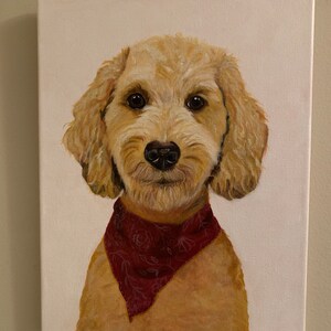 May include: A canvas painting of a golden doodle dog with a red bandana. The dog has brown eyes and a black nose. The painting is signed in the bottom right corner. The background is white.