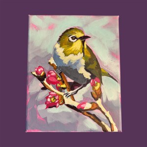 May include: An acrylic painting on canvas depicting a small bird with olive-green and white feathers perched on a brown branch. The branch features bright pink flower buds and blossoms. The background is a soft, abstract blend of light blue and pink.