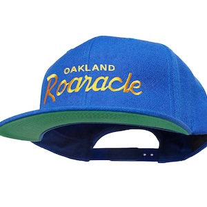 Oakland 90s Basketball Hat | Roaracle Vintage-Style Embroidered Royal Blue Snapback Cap with Yellow Script Lettering