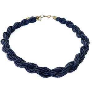 May include: A black beaded necklace with a twisted rope design.