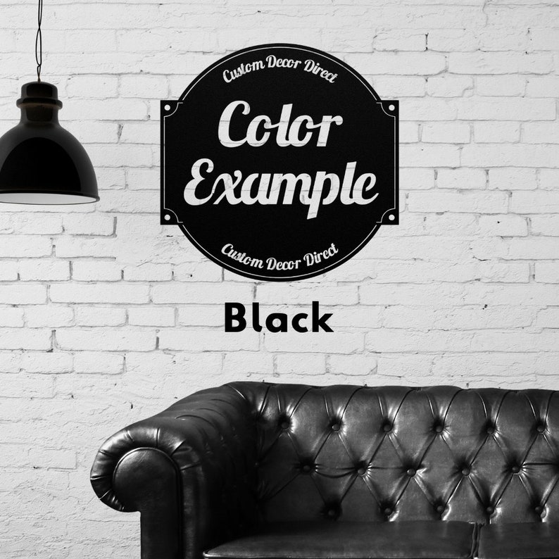 May include: Black and white sign with the text "Custom Decor Direct" and "Color Example" in a circle. The sign is on a white brick wall with a black leather couch in the foreground. The text "Black" is below the sign.