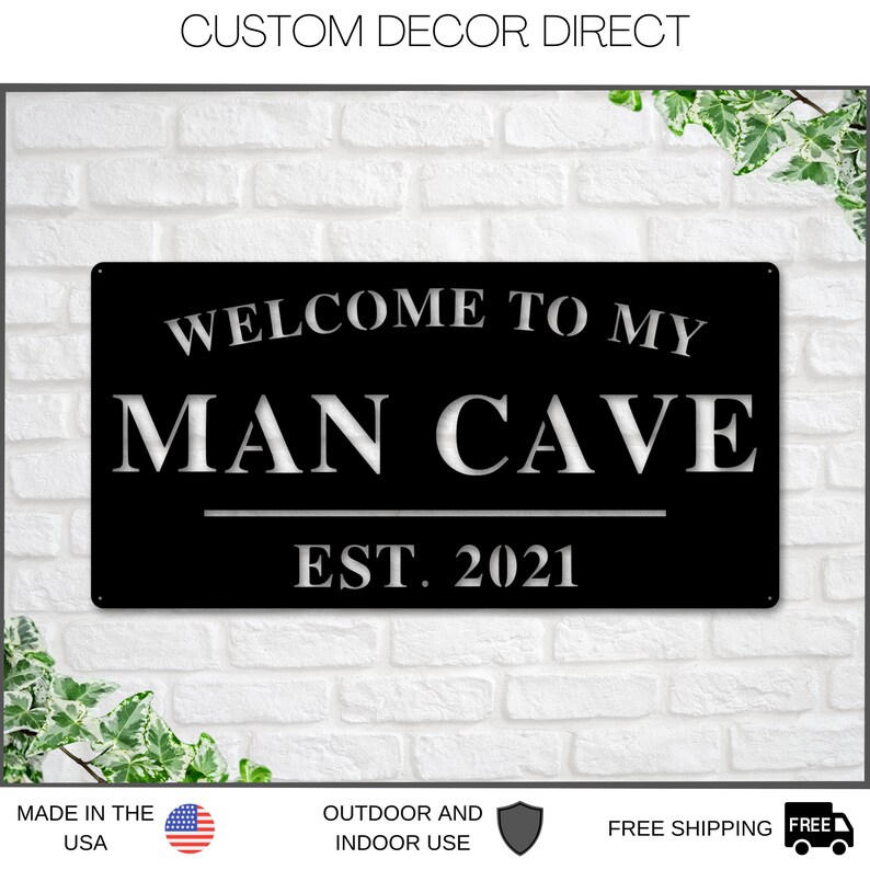 May include: Black metal sign with white lettering that reads "Welcome to my Man Cave Est. 2021".
