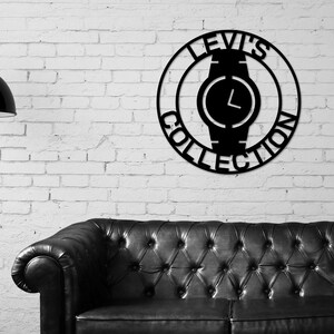 May include: Black metal wall art featuring a watch with the text "Levi's Collection" around the perimeter.