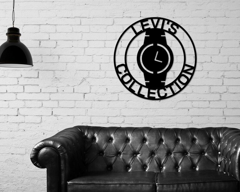 May include: Black metal wall art featuring a watch with the text "Levi's Collection" around the perimeter.